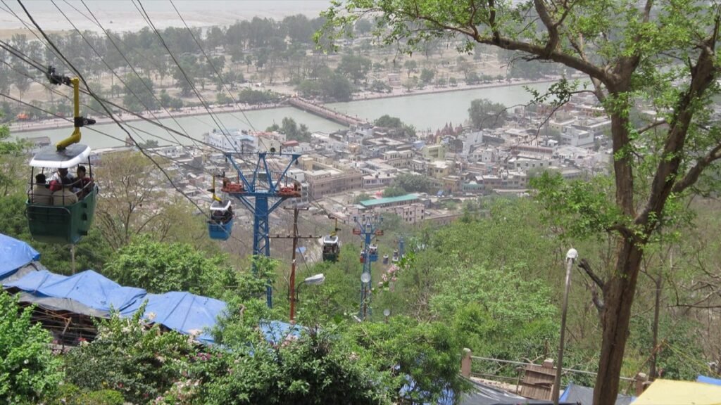 Ropeway cars climbing the hill above Haridwar, with the town and the Ganga below