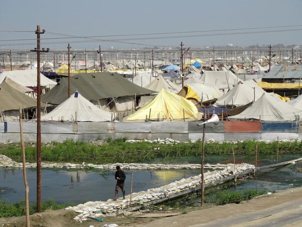 Rows of white and yellow pilgrim tents on the riverbed at the Sangam during the Magh Mela of 2014.