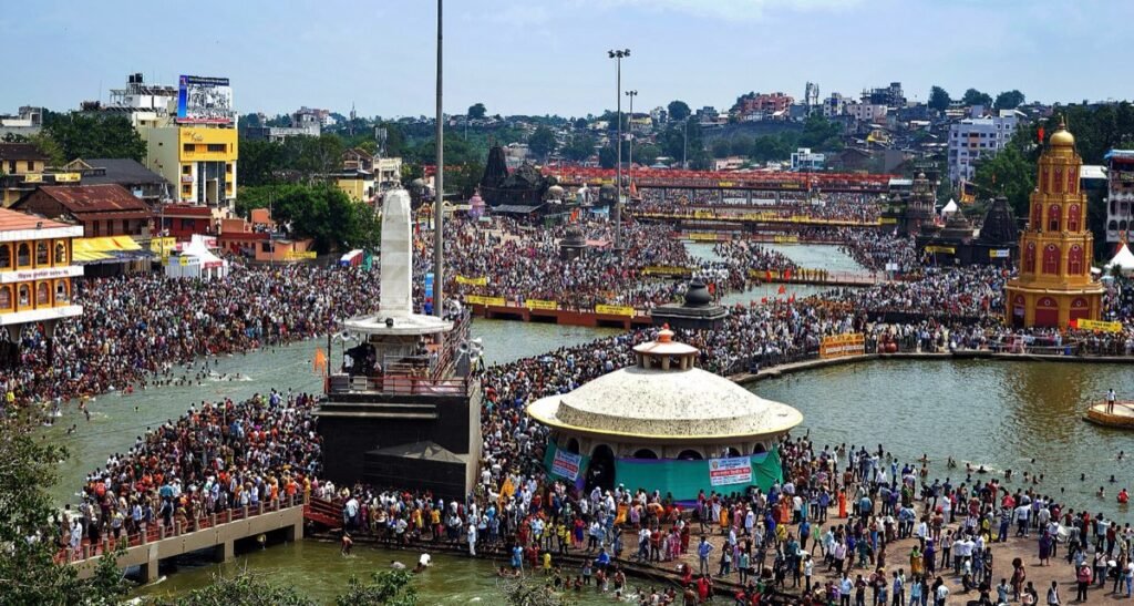 A wide view of pilgrims filling the Godavari ghats around Ramkund on a Kumbh Mela bathing day