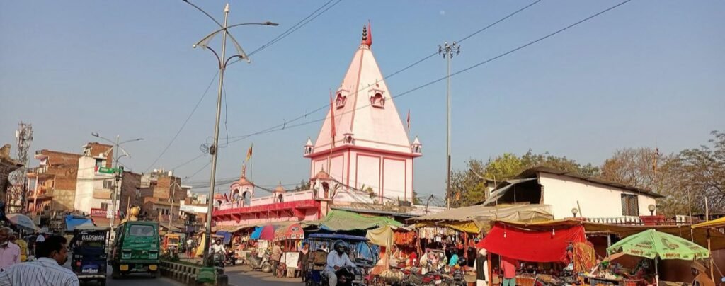 The pink shikhara of the Alop Shankari Devi Temple rising above a busy street in Prayagraj