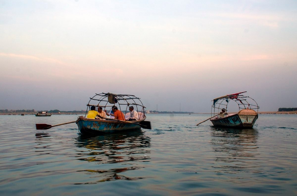 Rowing boats with pilgrims on the water at the Sangam, Prayagraj, in soft light
