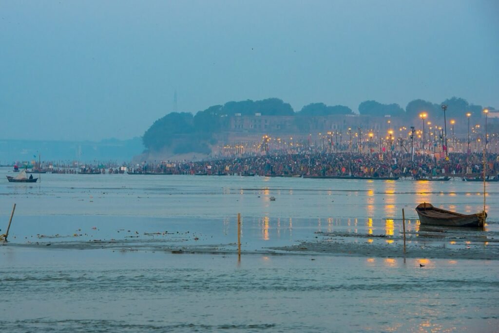 Dawn at the Sangam in Prayagraj on a Kumbh Mela bathing day in 2013, with pilgrims along the bank below the fort