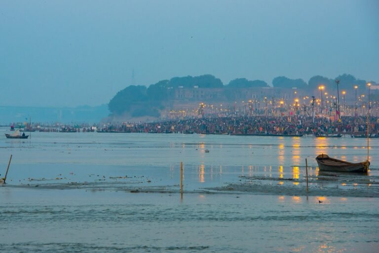 Dawn at the Sangam in Prayagraj on a Kumbh Mela bathing day in 2013, with pilgrims along the bank below the fort