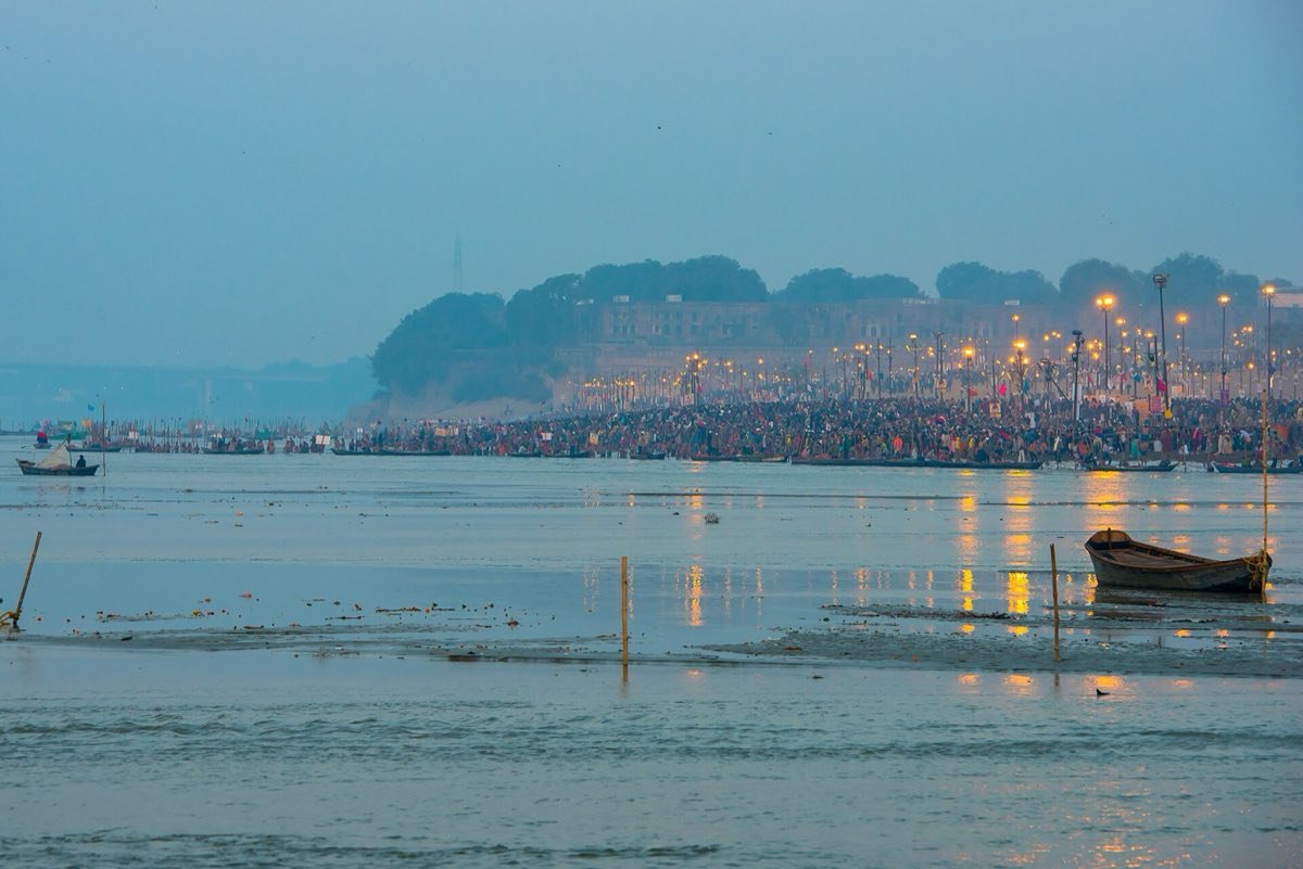 Dawn at the Sangam in Prayagraj on a Kumbh Mela bathing day in 2013, with pilgrims along the bank below the fort