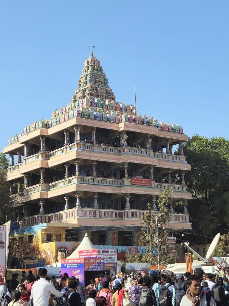 The tiered white Shankar Viman Mandapam temple near the Sangam, with pilgrims at its base.