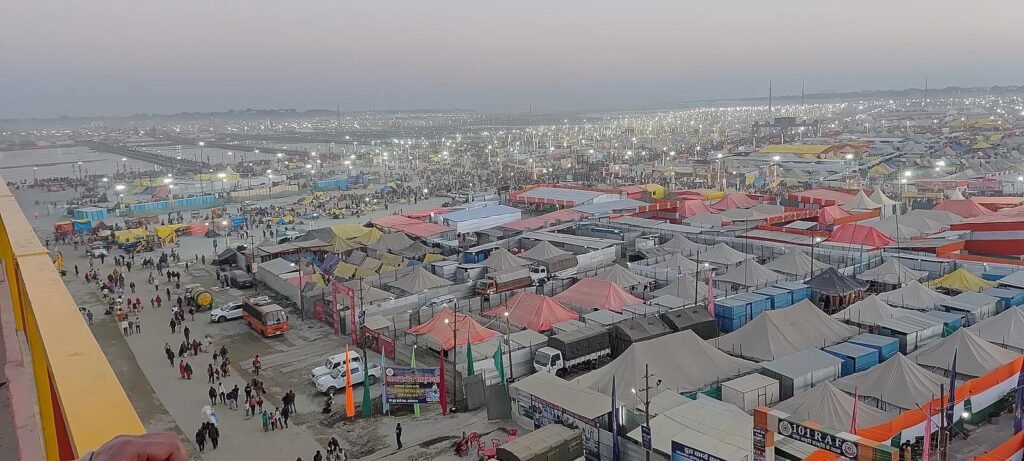 Rows of tents and camps of the Maha Kumbh 2025 spreading across the riverbed at Prayagraj, seen from a height.