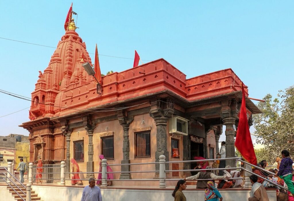 The Harsiddhi Temple in Ujjain, with saffron flags above its red shikhara and visitors on the steps
